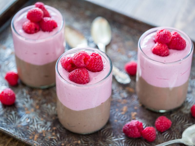 Chocolate Raspberry Parfaits on a metal baking tray with raspberries strewn between