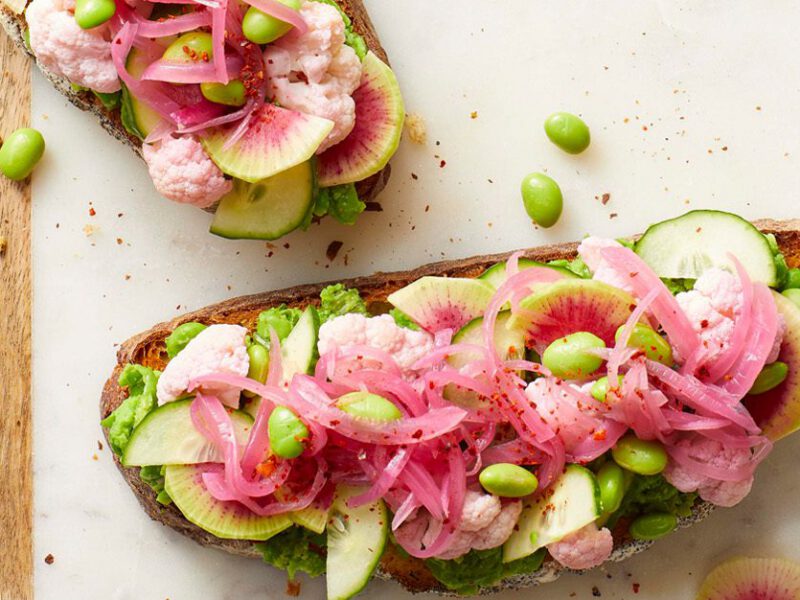 Lemony Spring Pea Toasts with watermelon radishes on a wood cutting board
