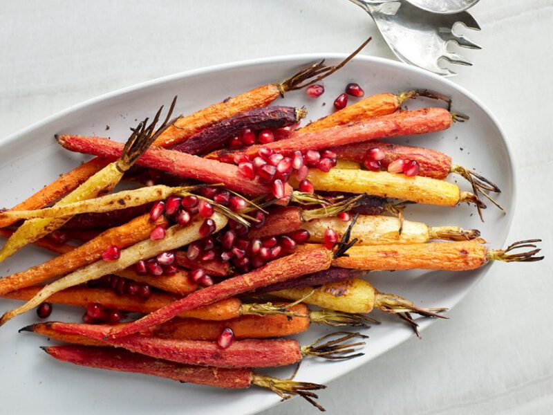 Cardamom Roasted Carrots with Pomegranate Seeds on a white serving dish