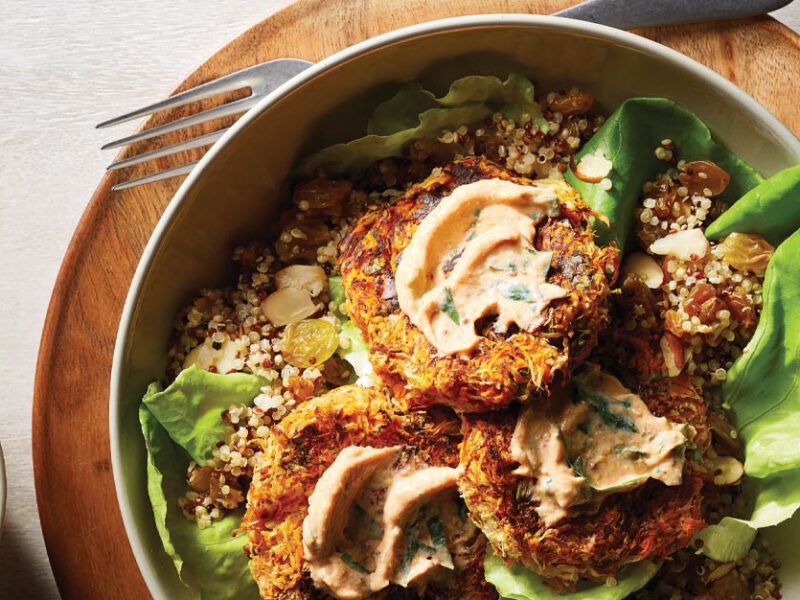 Turnip and Sweet Potato Croquettes with Quinoa Pilaf and Tofu Remoulade in a white bowl on a wooden plate next to a small bowl of the remoulade