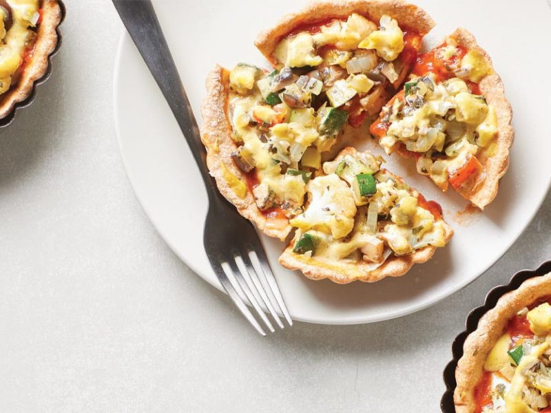 Mini Deep-Dish Pizza Pies in pie tins with one pie on a white plate