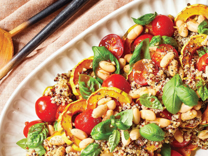 Balsamic-Roasted Delicata Squash Salad on a white serving platter with wooden serving spoons