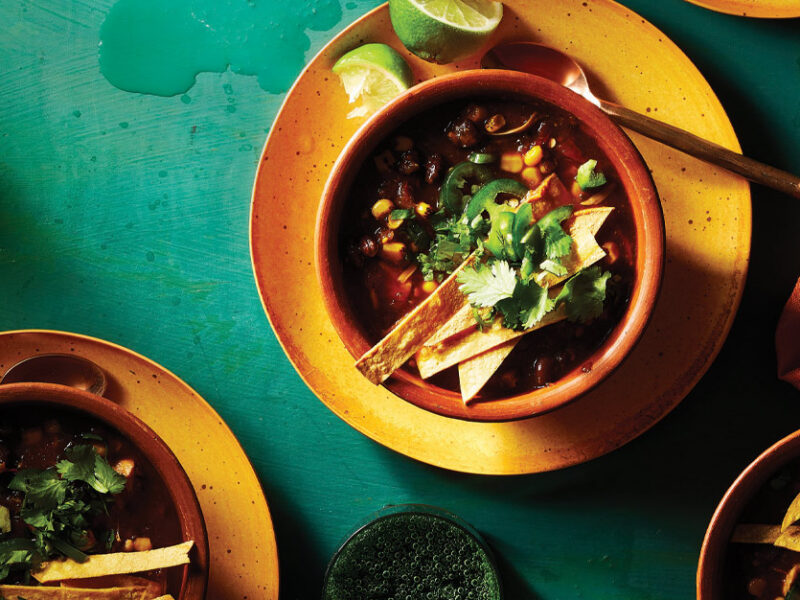 Vegan Taco Soup in terra cotta ceramic bowls against a green background