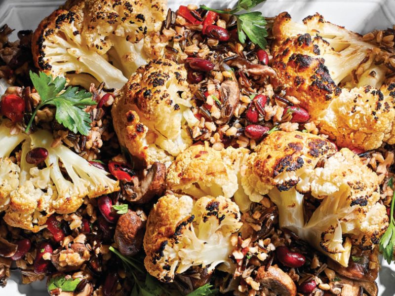 Whole Braised Cauliflower with Mixed-Grain Pilaf on a white serving platter