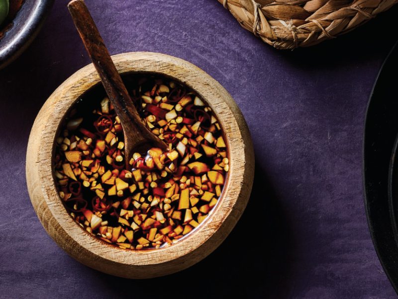Garlic Dipping Sauce in a rustic brown bowl with a small wooden spoon resting in the bowl