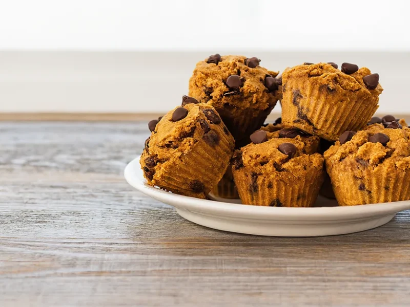 Chocolate Pumpkin Muffins piled high on a white plate