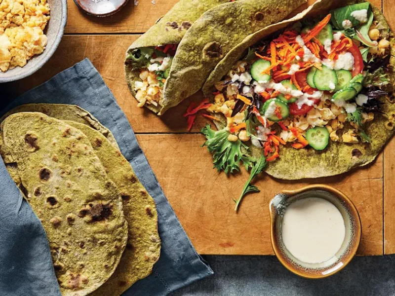 Chickpea Wraps with Homemade Spinach Tortillas on a wood tabletop