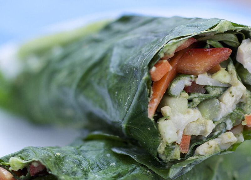 Veggie Wraps with Herbed Hummus on a white plate, cut in half, with one up on top of the other