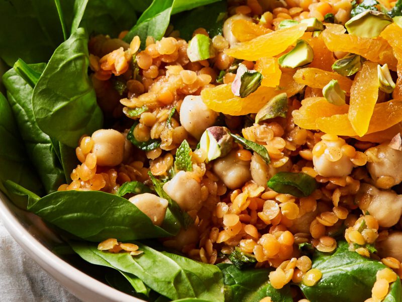 Spinach-Apricot Salad with Spiced Lentils next to a small bowl of dried apricot slices